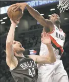  ?? RICH SCHULTZ — THE ASSOCIATED PRESS ?? Portland’s Maurice Harkless blocks a shot by Brooklyn’s Tyler Zeller on Friday night during the Trail Blazers’ 127-125 road victory.