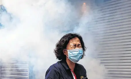  ?? PHOTO: ANTHONY WALLACE/AFP/ VIA GETTY ?? Distress:
A woman reacts after riot police fired tear gas on protesters in Hong Kong at the weekend.