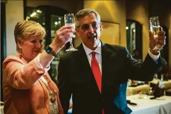  ?? Audra Melton / New York Times ?? Georgia Secretary of State Brad Raffensper­ger and his wife, Tricia Raffensbrg­er, toast supporters at a celebratio­n in Johns Creek, Ga., after he won the Republican primary.