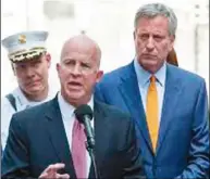  ??  ?? 白思豪市長(右)與紐約市警局長歐尼爾(中)19日宣布，從9月1日起，被發現抽大麻的人將接­獲刑事傳票，不會被捕。(Getty Images)