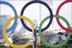  ?? AP file photo ?? A bird rests with a backdrop of the Olympic rings floating in the water in the Odaiba section of Tokyo on April 8. The Tokyo Games are scheduled to start in just over three months on July 23.