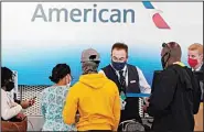  ?? (AP) ?? American Airlines employees work at ticket counters in Terminal 3 at O’Hare Internatio­nal Airport in Chicago, Friday, July 2, 2021.