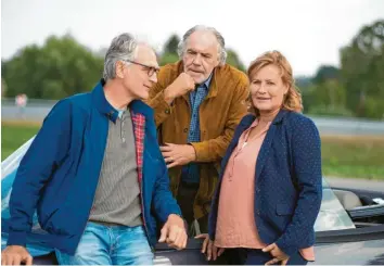  ?? Foto: Thorsten Jander/ARD Degeto, dpa ?? Walter Sittler (links, in der Rolle von Alexander Senn), Christian Kohlund (Georg Fischer) und Suzanne von Borsody (Christine Fischer) stehen in der Komödie „Der Liebhaber meiner Frau“an einem Auto.