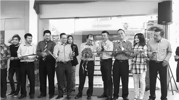  ??  ?? Lim (fifth right) cutting the ribbon to mark the opening of the new office at Trinity Hub here yesterday.