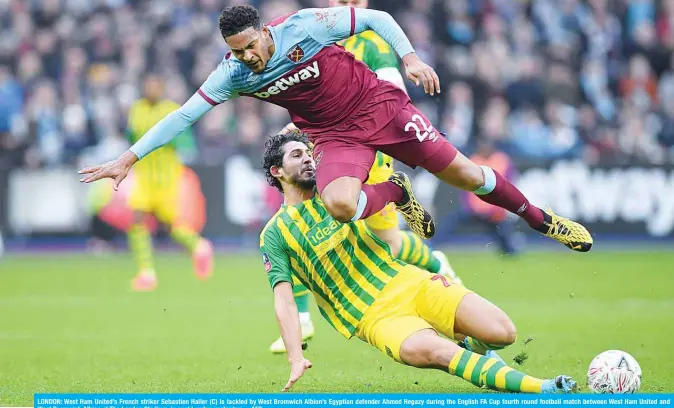  ?? —AFP ?? LONDON: West Ham United’s French striker Sebastien Haller (C) is tackled by West Bromwich Albion’s Egyptian defender Ahmed Hegazy during the English FA Cup fourth round football match between West Ham United and West Bromwich Albion at The London Stadium, in east London yesterday.