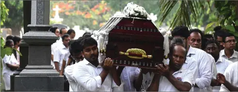  ??  ?? oelatives are seen carrying the coffin of a bomb blast victim for a burial ceremony at a cemetery in Colombo. — Acm photo