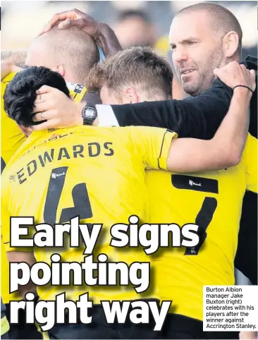  ??  ?? Burton Albion manager Jake Buxton (right) celebrates with his players after the winner against Accrington Stanley.