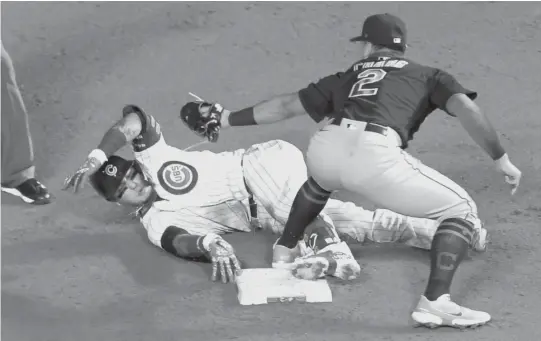  ?? MARK BLACK/AP ?? Javy Baez is tagged out by Indians second baseman Yu Chang after trying to stretch a single into a double in the second inning Wednesday at Wrigley Field.