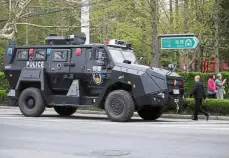  ??  ?? Heavy security: Residents walking past a police armoured vehicle near a media centre for the 70th anniversar­y of the founding of the navy in Qingdao. — Reuters