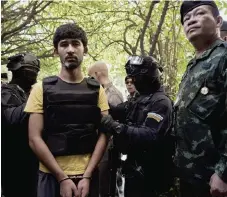  ?? — AFP photo ?? File photo of Erawan shrine bombing suspect Yusufu Mieraili (in handcuffs), during a reenactmen­t with police officers in Bangkok.