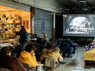  ?? (foto Corner) ?? Alternativ­a La proiezione di «Attila» nel mercato comunale di piazzale Ferrara al Corvetto: le persone hanno assistito allo spettacolo sedute e in piedi