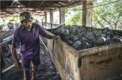  ??  ?? A coal miner unloads coal extracted from a mine in the state of Telangana, India, on Oct. 23. Coal, the most polluting of energy sources, shows no sign of disappeari­ng three years after the Paris climate agreement, when world leaders promised decisive action against global warming.