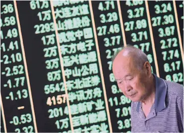  ?? PHOTO: EPA-EFE ?? A man walks past a digital display in Hangzhou, China. Due to the increase in tariffs on $200 billion of US exports, the Shanghai and Shenzhen stock markets fell sharply yesterday, and were down more than 2 percent.