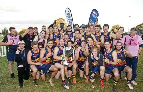  ?? Photos: Nev Madsen ?? THREE-PEAT: The USQ Cougars celebrate their 75-51 AFL Darling Downs men’s victory over the Goondiwind­i Hawks at Rockville Oval on Saturday.
