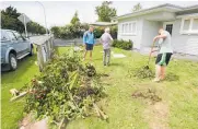  ?? Photo / Warren Buckland ?? Cleaning up after a car smashed through a fence, took out trees, and hit the house.