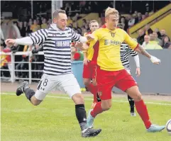  ??  ?? Marking Rovers’ Gary Phillips fending off Queen’s Park’s Darren Miller