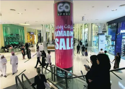  ?? Christophe­r Pike / The National ?? Shoppers packed malls around the country yesterday ahead of Eid Al Fitr. At Dubai Mall, above, posters advertised bargains for the festival that marks the end of Ramadan and the start of Shawaal, the 10th month of the Islamic lunar calendar.