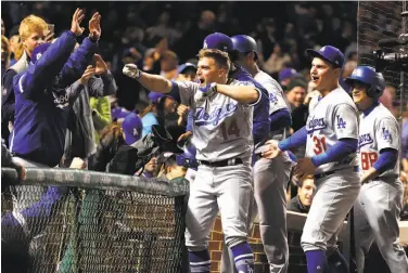  ?? Jamie Squire / Getty Images ?? Enrique Hernandez (14) celebrates with teammates after hitting a grand slam to put L.A. up 7-0.