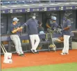  ?? Mike Carlson / Associated Press ?? Members of the Tampa Bay Rays await the start of a scrimmage in St. Petersburg, Fla.