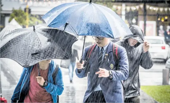  ?? Photo / Michael Craig ?? Heavy rain in central Auckland sent people scurrying for cover.