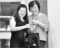  ??  ?? Quality assurance executive/infection control nurse Hii Lu Kiong (left) accepts the lucky draw grand prize of Tissot couple watches from East Malaysia regional general manager Yeoh Kim Looi.