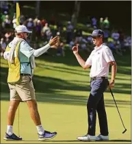  ?? Stacy Revere / Getty Images ?? J.T. Poston celebrates with his caddie Aaron Flener after putting to win on the 18th green during the final round of the John Deere Classic at TPC Deere Run on Sunday in Silvis, Ill.