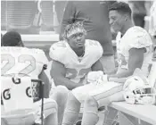  ?? WILFREDO LEE/AP ?? Dolphins running back Kalen Ballage, center, talks to Mark Walton, left, and Kenyan Drake on the sidelines during their game against the Los Angeles Chargers on Sept. 29.