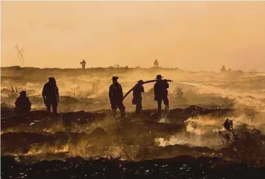  ?? AFP PIC ?? Soldiers and firefighte­rs battling fire in a garbage dump in Yangon on Wednesday.