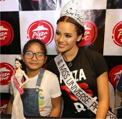  ?? -Chris Navarro ?? MEET AND GREET
Miss Universe Philippine­s 2018 Catriona Gray poses with a girl cuddling a Ms. Universe doll during Saturday's meet and greet at Pizza Hut , SM City San Fernando DownTown.