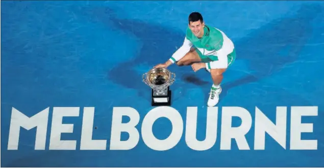  ??  ?? Novak Djokovic posa en la pista del Rod Laver Arena con la Norman Brookes Challenge Cup, el trofeo que le acredita por novena vez como campeón del Open de Australia.