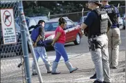  ?? ROGELIO V. SOLIS / ASSOCIATED PRESS ?? Two people are taken into custody at a Koch Foods Inc. plant in Morton, Miss., on Wednesday. U.S. immigratio­n officials raided several Mississipp­i food processing plants.