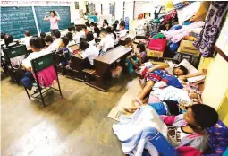  ??  ?? SHARING SPACE – A class is in progress in Daraga, Albay, while evacuees from villages near Mount Mayon huddle with their belongings at the back of the classroom. Many schools in Albay have been designated as evacuation centers. (Czar Dancel)