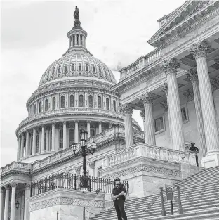  ?? REUTERS • ERIN SCOTT ?? Police officers wearing face masks guard the U.S. Capitol Building in Washington, U.S., May 14, 2020.