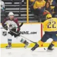  ?? Andy Cross, The Denver Post ?? Avalanche center Alexander Kerfoot slides the puck past Nashville Predators left wing Kevin Fiala on Saturday. Kerfoot is one of nine Avalanche players to make their NHL postseason debuts.