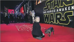  ?? AP PHOTO ?? Carrie Fisher is used to feeling the love from “Star Wars” fans, but some younger devotees have left the screen star in stitches with their unexpected reactions to meeting Princess Leia in real life. Fisher poses for photograph­ers with a dog upon...