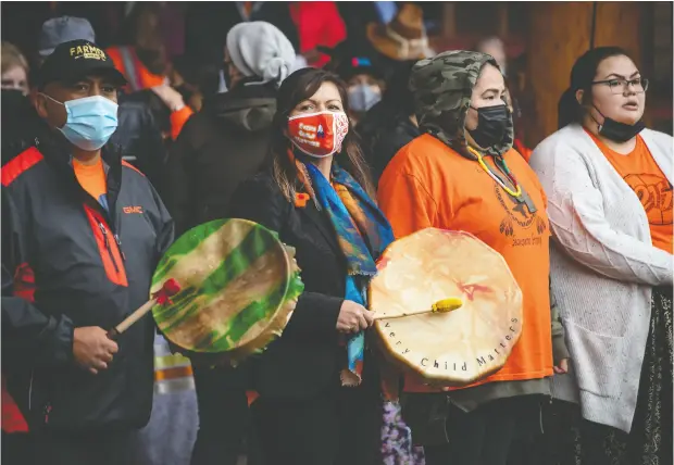  ?? DARRYL DYCK / THE CANADIAN PRESS FILES ?? Tk’emlups te Secwepemc chief Rosanne Casimir, second from left, plays a drum during a ceremony to mark the first National Day for Truth and
Reconcilia­tion, in Kamloops, B.C. Casimir criticized Prime Minister Justin Trudeau for taking a beach holiday rather than attending.