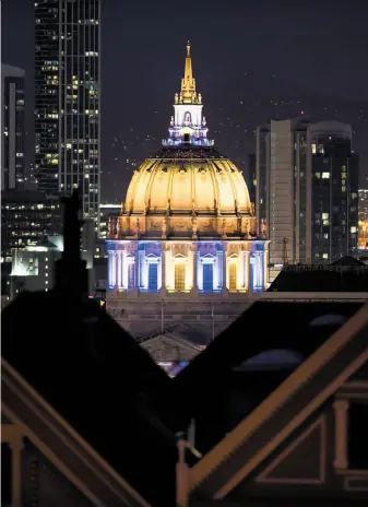  ?? Noah Berger / Special to The Chronicle ?? S.F. City Hall glowed in blue and gold colors after the Warriors defeated Cleveland in Game 3 of the NBA Finals Wednesday. Warriors fans hope they’ll see it again after Game 5 Monday night.