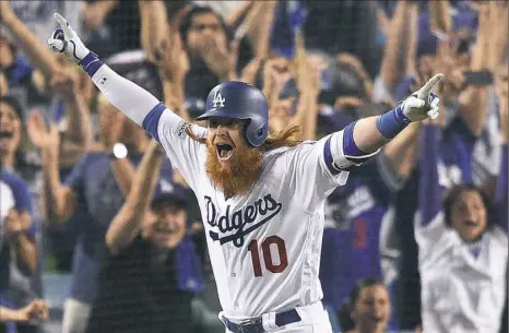  ?? Kevork Djansezian/Getty Images ?? Los Angeles’ Justin Turner celebrates after hitting a walk-off three-run home run in the ninth inning against the Chicago Cubs. The 4-1 win put the Dodgers up, 2-0, in the best-of-seven National League Championsh­ip Series.