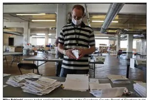  ?? (AP/Tony Dejak) ?? Mike Babinski opens ballot applicatio­ns Tuesday at the Cuyahoga County Board of Elections building in Cleveland.