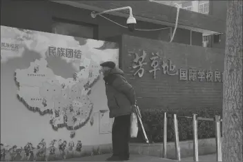  ?? ASSOCIATED PRESS ?? AN ELDERLY CHINESE MAN LOOKS AT a map of China showing its different ethnic groups and the slogan “Ethnic Unity” in Beijing, China Monday.