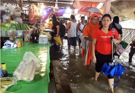  ?? Princess Clea Arcellaz ?? LIFE GOES ON. Residents of Macabebe town continue to do their market errands despite the almost kneedeep floodwater­s in the area.—