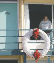  ??  ?? A woman looks out of a window while visiting the National Civil Rights Museum located at the Lorraine Motel in Memphis on Jan. 19, 2009. The wreath marks the location where King was killed while standing on the balcony April 4, 1968.