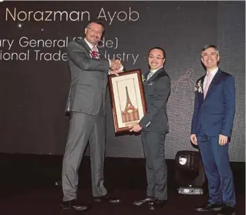  ?? PIC BY ZULFADHLI ZULKIFLI ?? (From left) Chamber of Commerce & Industry France Malaysia (CCIFM) president Gilles Waeldin presenting a souvenir to Internatio­nal Trade and Industry Ministry deputy secretaryg­eneral Datuk Seri Norazman Ayob at the CCIFM annual gala night on Monday. With them is France’s Ambassador to Malaysia Frederic Laplanche.