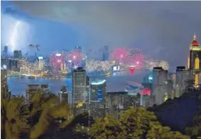  ?? THE ASSOCIATED PRESS ?? Lightning strikes as fireworks explode Saturday over Hong Kong’s Victoria Harbor to mark the 20th anniversar­y of Britain’s handover of the territory to China.