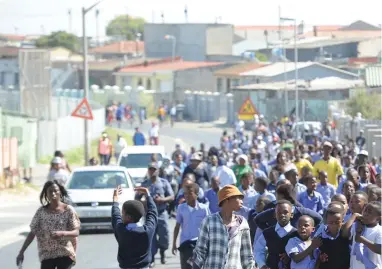  ?? PICTURE: HENK KRUGER ?? ‘PEACEFUL’: Parents of pupils from Mseki Primary School closed the school yesterday morning before marching with their children to the Gugulethu police station to protest against ‘overcrowdi­ng’.