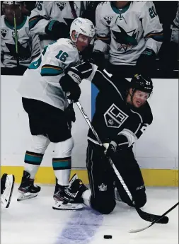  ?? MARK J. TERRILL — THE ASSOCIATED PRESS ?? Austin Wagner of the Kings passes the puck from his knees while under pressure from the Sharks’ Ryan Donato during Friday night’s 3-0 victory in Los Angeles.