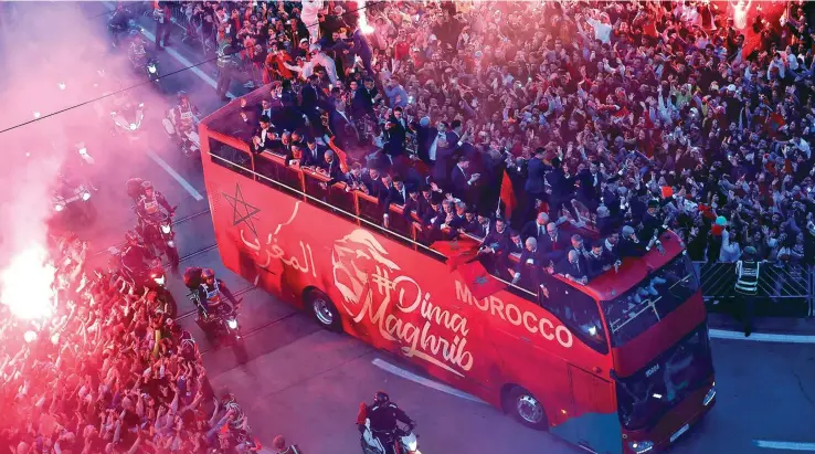  ?? Photo: Reuters ?? Morocco players on a bus touring the streets of Rabat as Morocco fans celebrate with flares during the parade on December 20, 2022.