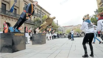  ?? Fotos: Oskar Montero ?? Instante en el que, soga al cuello, las estatuas de Felipe VI y Cristóbal Colón son derribadas.