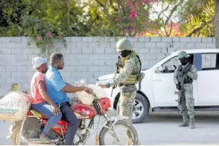  ?? AP PHOTOS ?? Soldiers inspect commuters at the entrance of the internatio­nal airport in Port-au-Prince, Haiti yesterday.