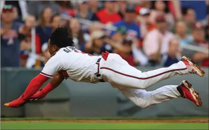  ?? File, Curtis Compton / AJC via AP ?? Atlanta’s Ozzie Albies loses his helmet while diving into third base after tagging up on a long fly ball against the San Francisco Giants.